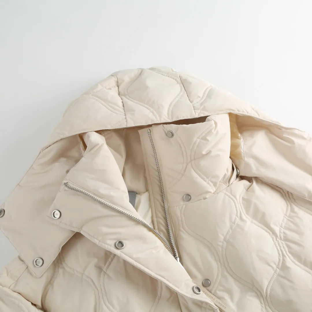 P1060 Canada Goose hooded down jacket fabric selection; nylon fabric is known for its high strength, excellent wear and tear resistance, and excellent durability. At the same time, it is light in texture, easy to move, and has excellent water-repellent function, which can effectively deal with light rain and humidity. Technology: Double-needle quilting technology is used. Double-needle quilting technology is a sophisticated sewing technology. Its core feature is to use two needles to quilt at the same time to form two parallel stitches. This design not only makes the quilting lines visually more three-dimensional, regular and refined, but more importantly, it greatly enhances the firmness of the sewing. The double lines in parallel form a more stable structure, which can effectively lock the internal filling and significantly prevent it from shifting, accumulating or velveting during wearing or washing, thereby ensuring that the thermal insulation layer is evenly distributed without cold spots, and comprehensively improves the durability and thermal efficiency of the product.    High-quality filling: It is filled with 90% selected white duck down, weighing 170g, ensuring fluffy rebound, lightness and warmth.  Accessories: one-to-one customized three-standard, one-to-one customized zipper, one-to-one customized hardware